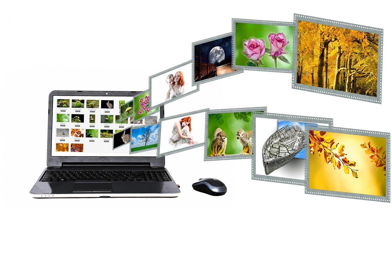 A laptop with a gallery of photos fanning out from its screen
